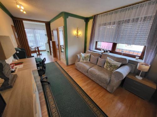 a living room with a couch and a window at Hotel Schönblick in Bad Herrenalb