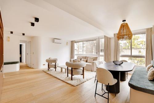 un salon blanc avec une table et des chaises dans l'établissement Pick A Flat's Apartments in Tour Eiffel - Rue de l'Amiral Hamelin, à Paris
