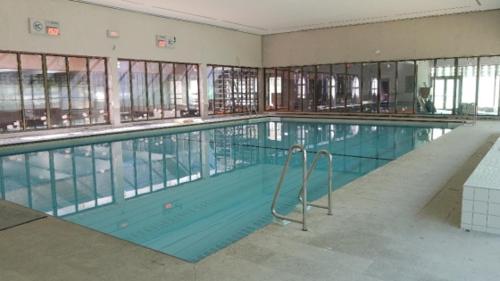 a large swimming pool in a large building at Xiu's home in Wielsbeke