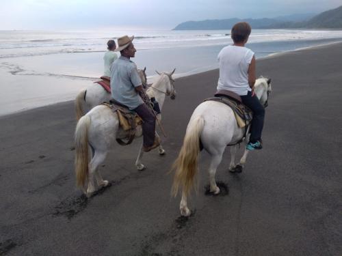 three people are riding horses on the beach at La Pepita de Cambutal in Cambutal