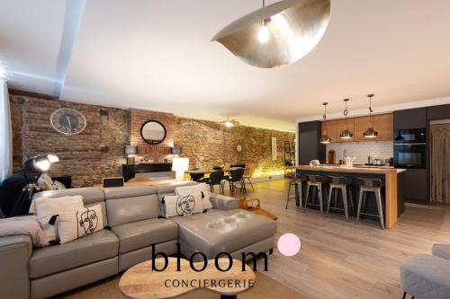 a large living room with a couch and a kitchen at Loft de Standing Nancy plein coeur in Nancy