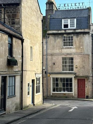 an old building with a red door on a street at Luxury Georgian Townhouse in Bath