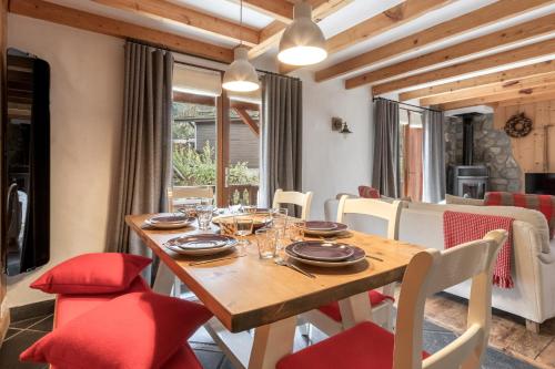 une salle à manger avec une table en bois et des chaises rouges dans l'établissement La Bastide - Grand chalet privé - Quartier calme, aux Houches