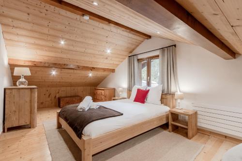 une chambre avec un lit dans une pièce aux murs en bois dans l'établissement La Bastide - Grand chalet privé - Quartier calme, aux Houches
