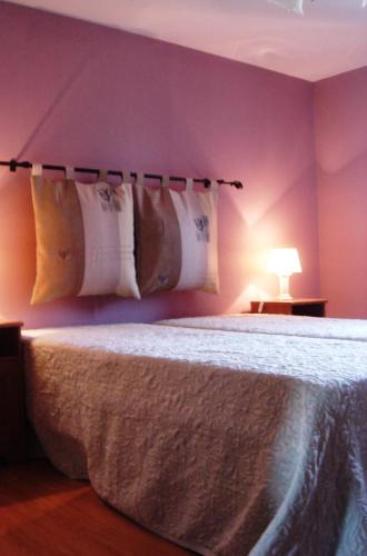 a bedroom with a bed with white sheets and pillows at La Petite Ferme in Rochehaut
