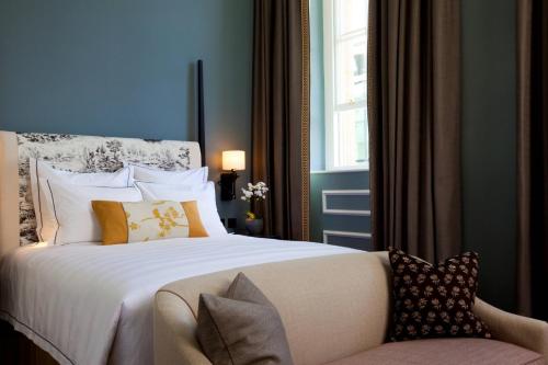 a bedroom with a bed and a couch and a window at The Gainsborough Bath Spa - Small Luxury Hotels of the World in Bath