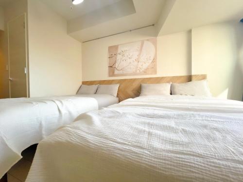 two beds sitting next to each other in a bedroom at Shinjuku Downtown BZT Free WiFi in Tokyo