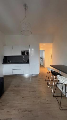 Una cocina con gabinetes blancos y una mesa y sillas. en SUITE grassi, en Bresso