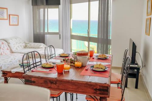 a dining room table with food and orange juice on it at Host Wise - Terrace & Ocean View Flat in Armação de Pêra