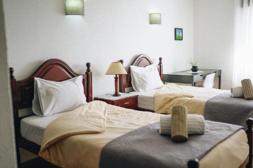 a hotel room with two beds and a desk at Host Wise - Terrace & Ocean View Flat in Armação de Pêra