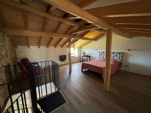 a bedroom with a pink bed in a room with wooden ceilings at La Casita de Patones in Patones