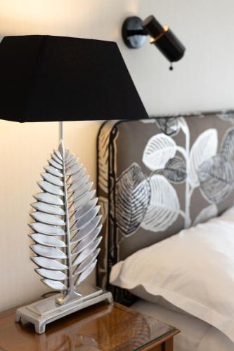 a lamp on a table next to a bed at LA RESERVE ALBI Hôtel Restaurant in Albi