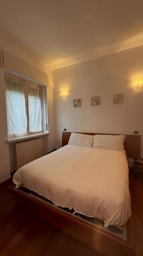 a bedroom with a large white bed with a window at Antonella's House in Bresso