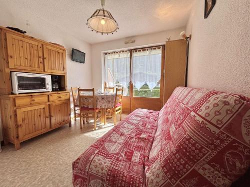 une chambre avec un lit et une cuisine avec une table dans l'établissement Studio Cabine avec Terrasse, Parking et Proche Pistes - Praz-sur-Arly - FR-1-603-28, à Praz-sur-Arly