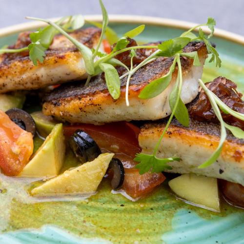 a plate of food with grilled fish and vegetables at Gonville Hotel in Cambridge