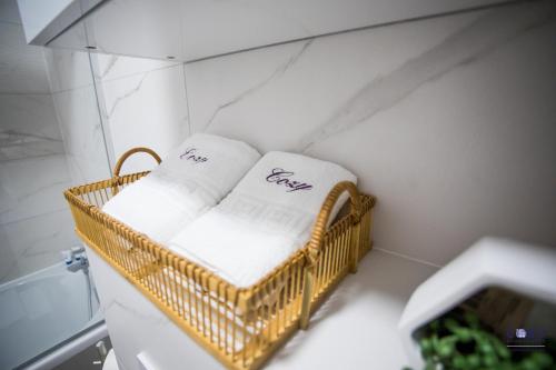 einen Korbkorb mit Handtüchern im Bad in der Unterkunft Exclusive Cozy Apartment Adora Park Arad in Arad