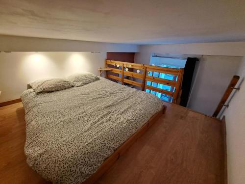 une chambre avec un lit et un parquet dans l'établissement Charmant studio gare intra-muros, à Saint-Malo