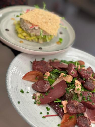 two plates of food with meat and a sandwich at Hôtel de la Tabletterie in Méru