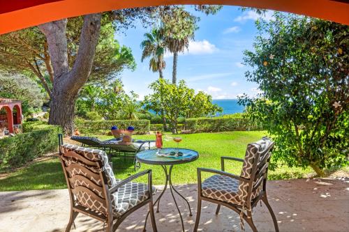 a patio with a table and chairs and the ocean at Boutique Hotel Vivenda Miranda in Lagos