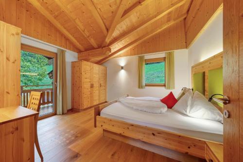 a bedroom with a bed in a wooden house at Thalerhof Appartement Christine in Verano