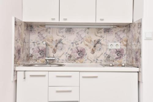 cocina con fregadero y papel pintado con motivos florales en Charming Studio in City Center-Excellent Location, en Sarajevo