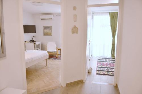 Un dormitorio con una cama y un escritorio y una ventana. en Charming Studio in City Center-Excellent Location, en Sarajevo