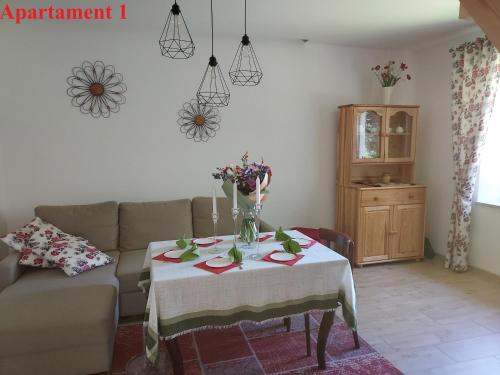 a living room with a table with flowers on it at Noclegi nad Czarną Orawą in Podwilk