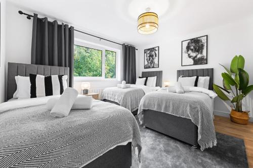 a bedroom with two beds and a window at Stylish 2BR Flat near Airport & Stadium, Sleeps 6 in Luton