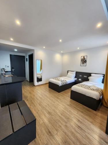 a hotel room with two beds and a sink at Miami Suites Tamatave in Toamasina