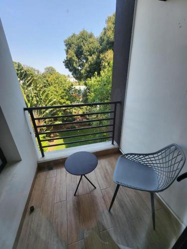 a room with a chair and a stool on a balcony at Miami Suites Tamatave in Toamasina