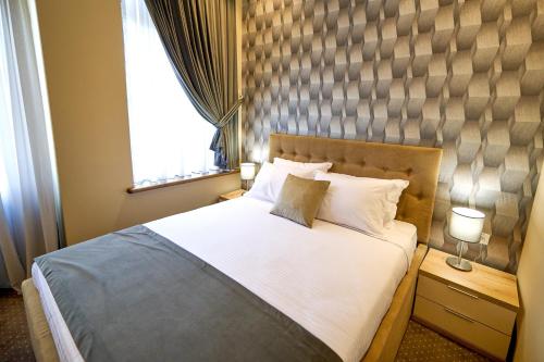 a bedroom with a large bed and a window at G Danube Boutique Hotel in Brăila
