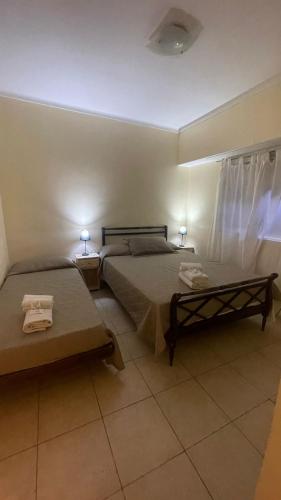 een slaapkamer met 2 bedden en 2 tafels en 2 lampen bij Hotel gade in Mar del Plata
