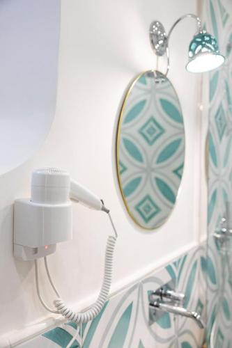 a bathroom with a mirror and a light on a wall at B & B Boutique Epoca in Salerno