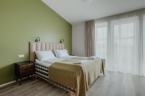 a bedroom with a large bed and a window at Hótel Eldhestar in Hveragerði