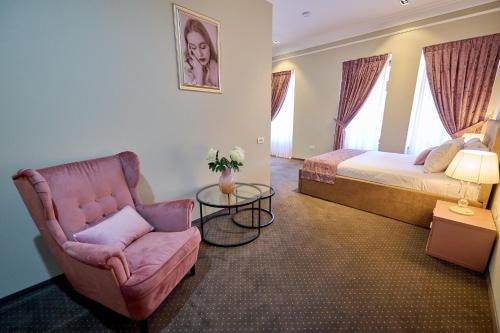 a bedroom with a bed and a chair and a table at G Danube Boutique Hotel in Brăila