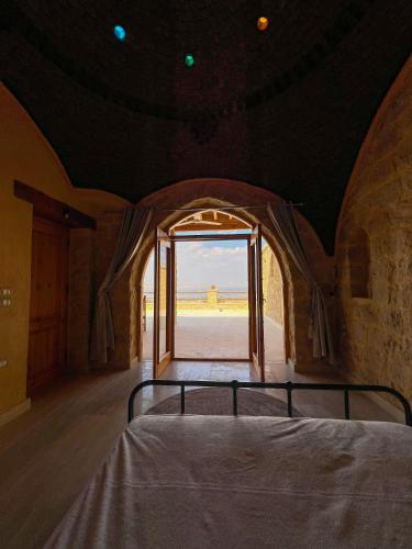 a bed in a room with an open door at Hoopoe lodge in Tunis