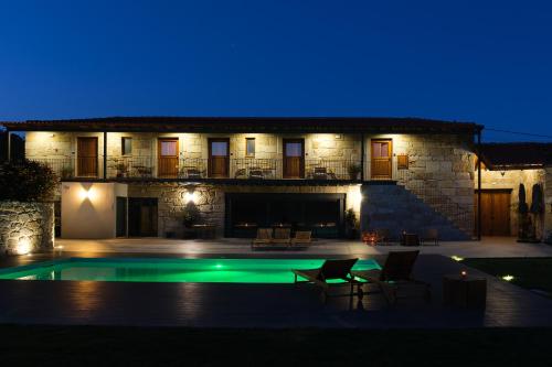 a villa with a swimming pool at night at Casa Vieira Lobo in Arouca