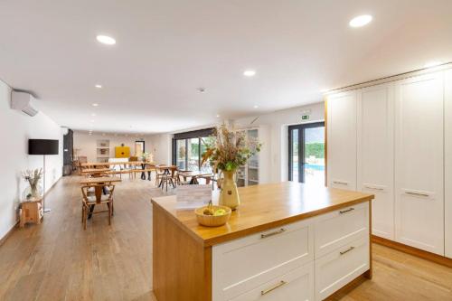 a kitchen with white cabinets and a dining room at Casa Vieira Lobo in Arouca