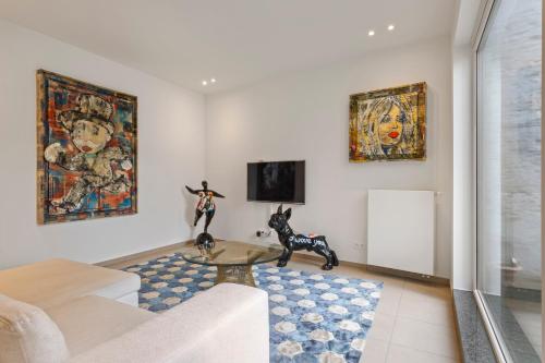 a living room with a couch and paintings on the wall at Residentie Nevejan in Kortrijk