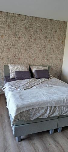 a bed with two pillows on it in a bedroom at B&B De Blauwe Melkbus in Harskamp