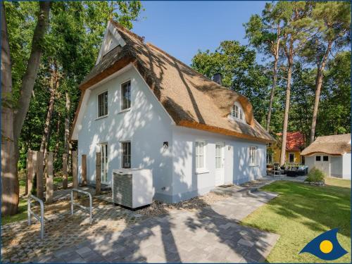 a white house with a brown roof at Fischerdorf Zirchow Seebär in Zirchow