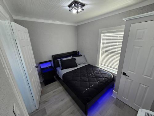 a bedroom with a bed with a blue light at Casa moderna, a newly renovated Modern apartment in West Palm Beach