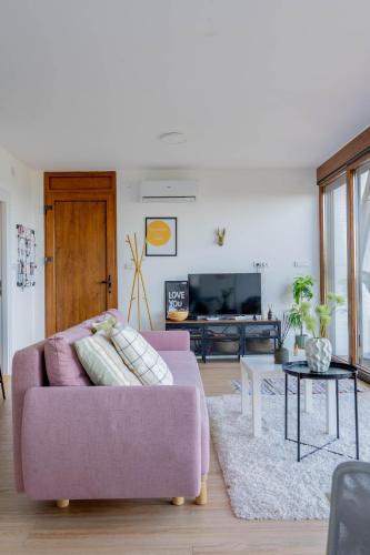 a living room with a pink couch and a table at Rent a NEST in Arandjelovac