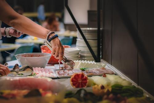 a person preparing food in a buffet line at Amura Alcobendas in Alcobendas
