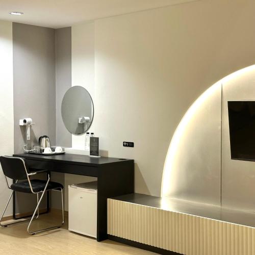 a room with a desk with a mirror and a refrigerator at Lune bangkok in Bangna