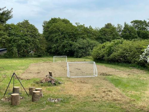 a soccer field with a net and logs and trees at Beautiful Home In Højslev W- in Højslev