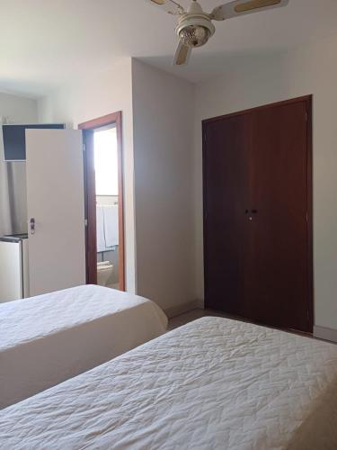 a bedroom with two beds and a large closet at Hotel Dominguez Master in Nova Friburgo