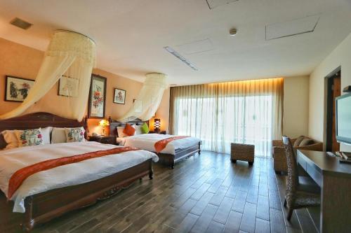 a hotel room with two beds and a flat screen tv at The Mudan in Checheng