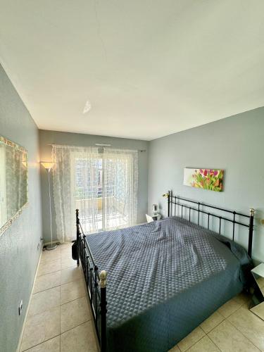 une chambre avec un lit et une grande fenêtre dans l'établissement 2 pieces proche mer GOLDEN, à Cannes