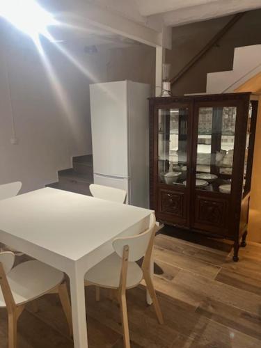 a kitchen with a white table and chairs and a refrigerator at Añisclo in Barbastro